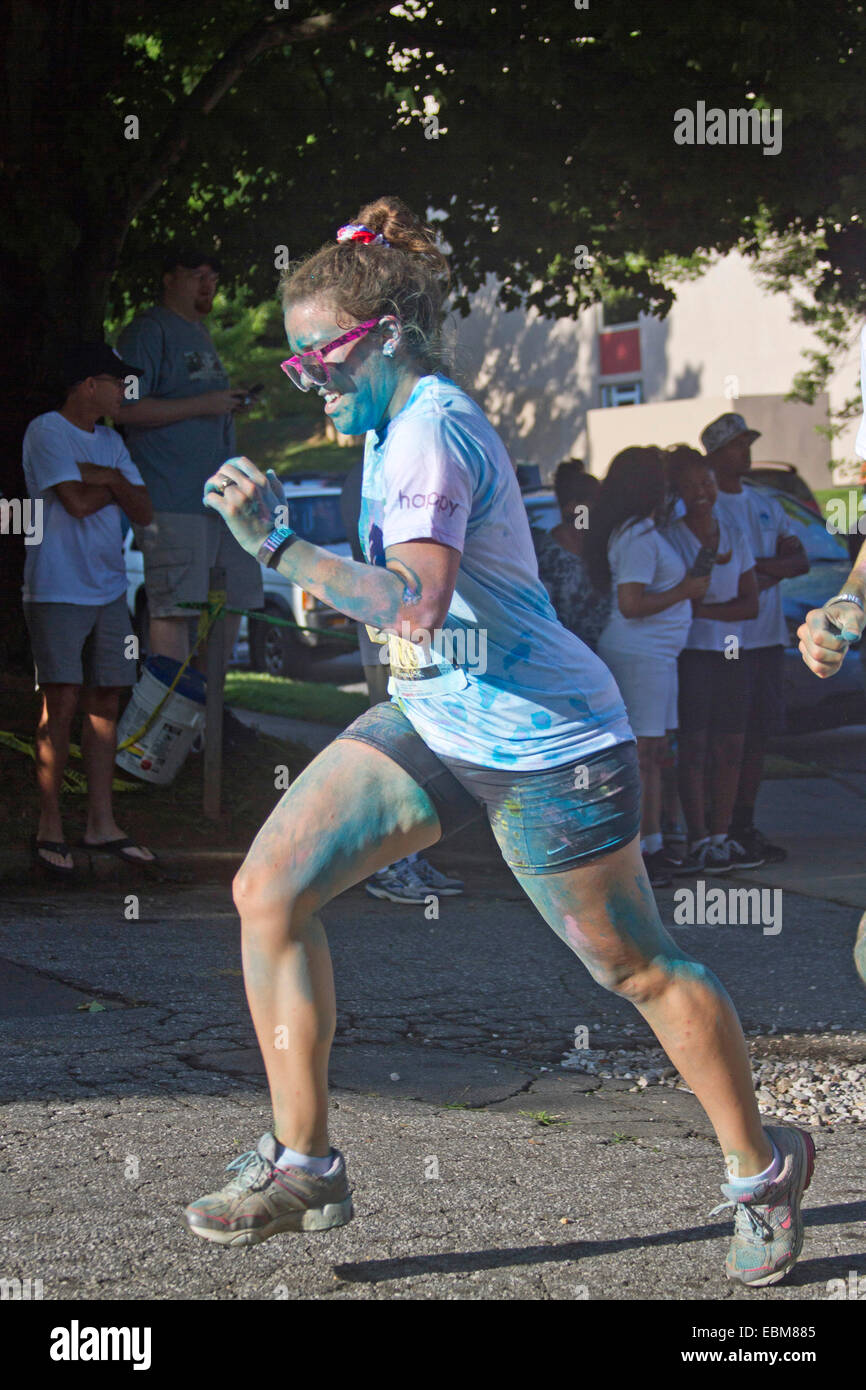 Ein Frau Läufer spritzte mit Farbstoff-Rennen in der happy Asheville 5K Farbe Run Stockfoto