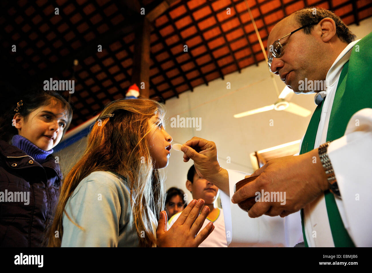 Katholische Kinder Masse, Priester geben Kommunion, ein Mädchen, San Joaquin Caaguazu Abteilung, Paraguay Stockfoto