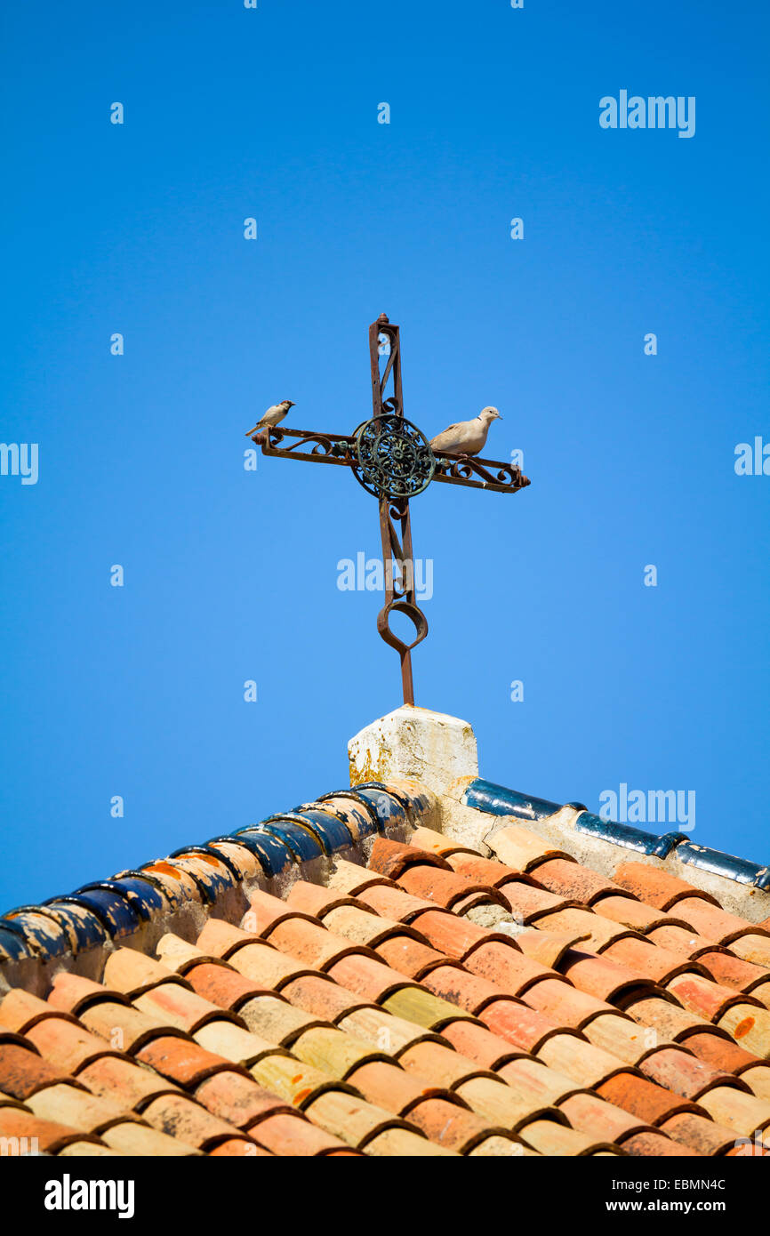 Dach mit alten schmiedeeisernen Kreuz und zwei Vögel drauf Stockfoto