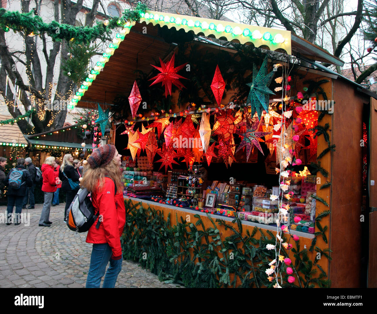 Junge Frau, die Dekorationen in Freiburg Weihnachtsmarkt bewundern Stockfoto
