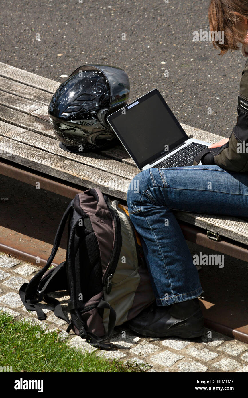 Frau sitzt auf Sitzbank mit einem laptop Stockfoto