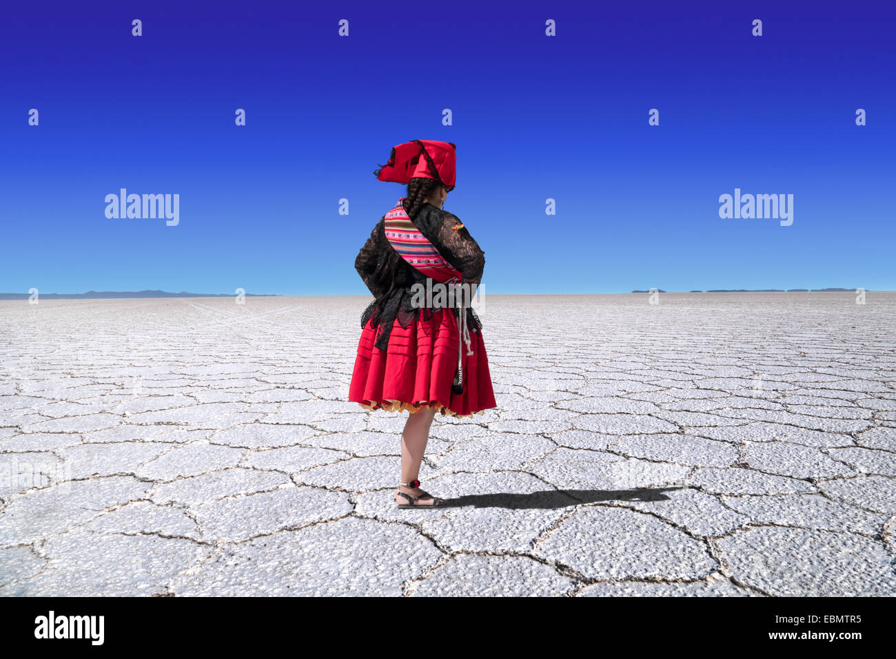 Heckansicht des bolivianischen Frau mit Folklore Kleid in der Wüste von Uyuni, Bolivien Stockfoto