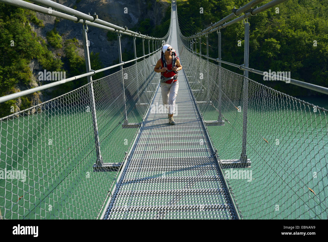 weibliche Wanderer auf Aussetzung Brücke über See Lac de Besitzer-Avignonet, Frankreich, Grenobl Stockfoto