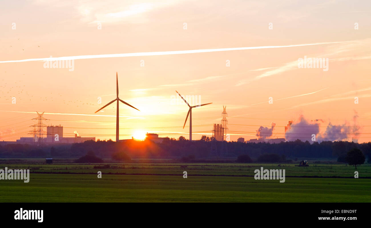 Feld-Landschaft mit Windkraftanlagen im Sonnenaufgang, Arcelor Mittal Stahlwerk im Hintergrund, Deutschland, Bremen Stockfoto