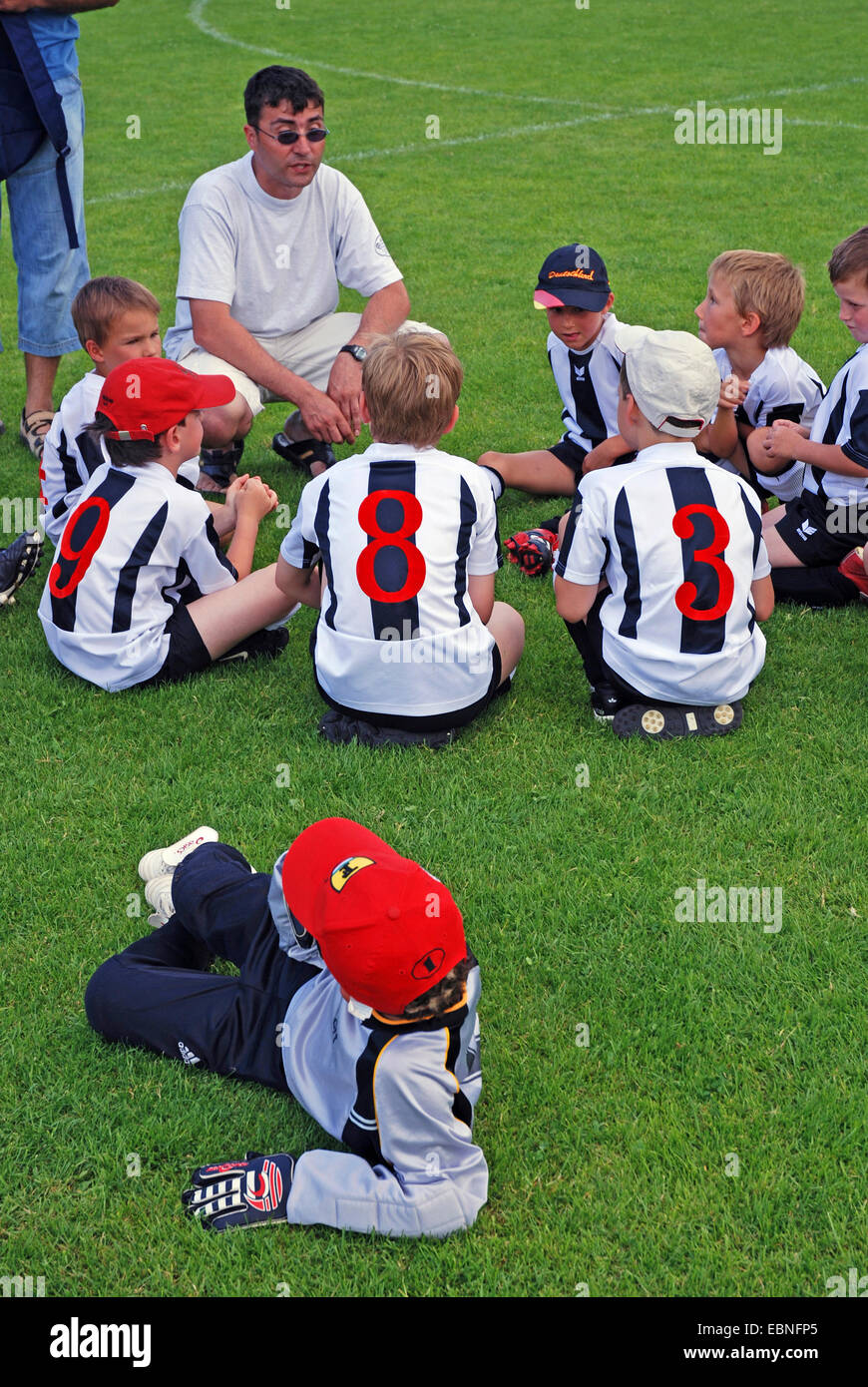 Juvenile Football-Trainer bei einem Turnier sammeln von seinem Team auf dem Rasen, Deutschland, Baden-Württemberg Stockfoto