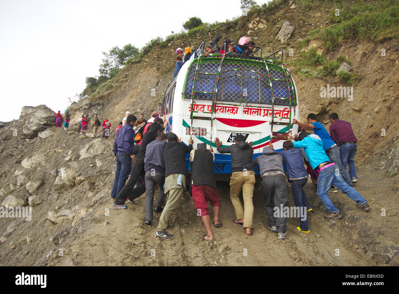 Leute, die einen Bus auf einer schlammigen Straße auf dem Weg nach Dhunche, Nepal Langtang Himal Stockfoto