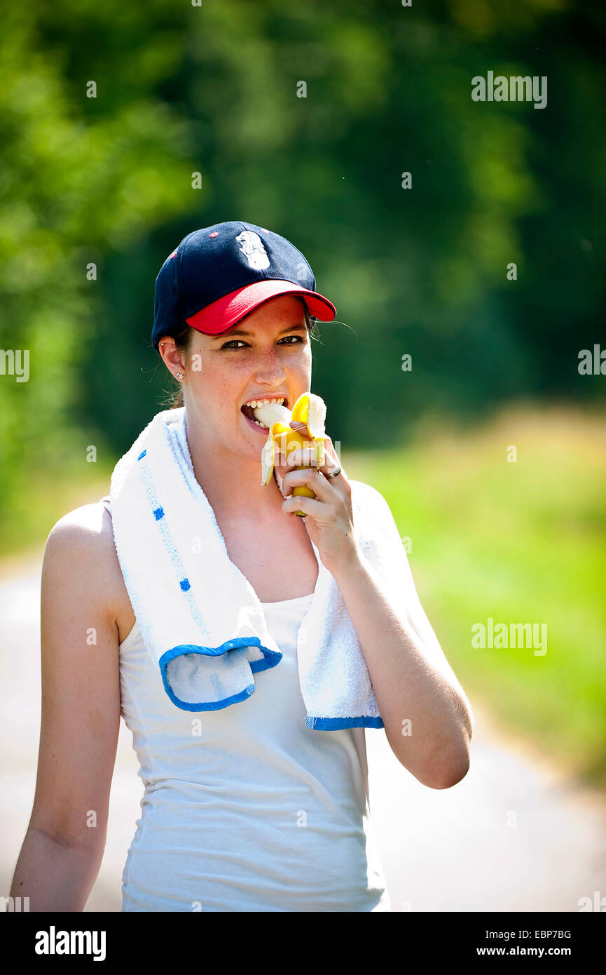 junge Frau eine Banane essen, nach dem Outdoor-Sport Stockfoto