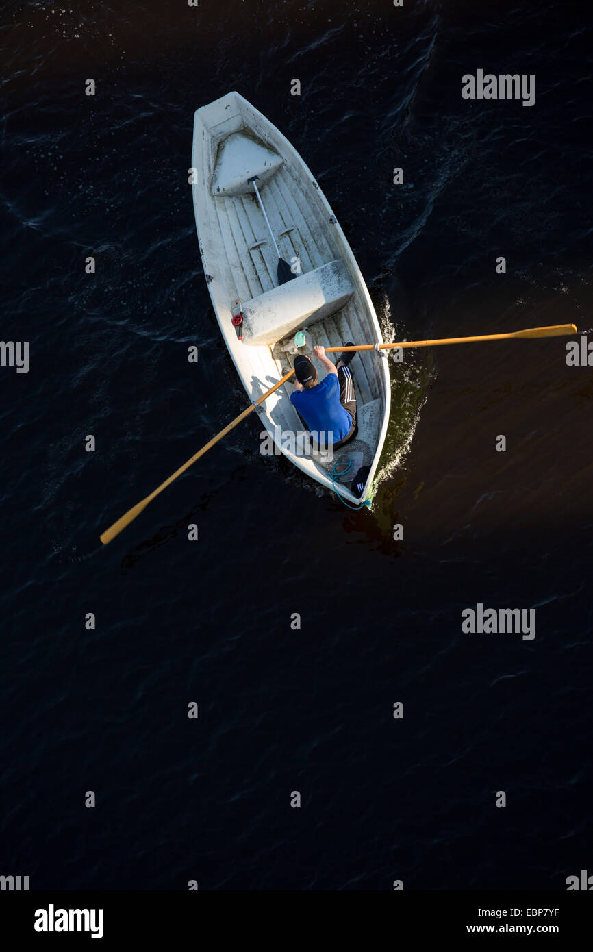 Luftaufnahme eines Mannes, der ein Fiberglas-Ruderboot / Schiff / Beiboot rudert, Finnland Stockfoto