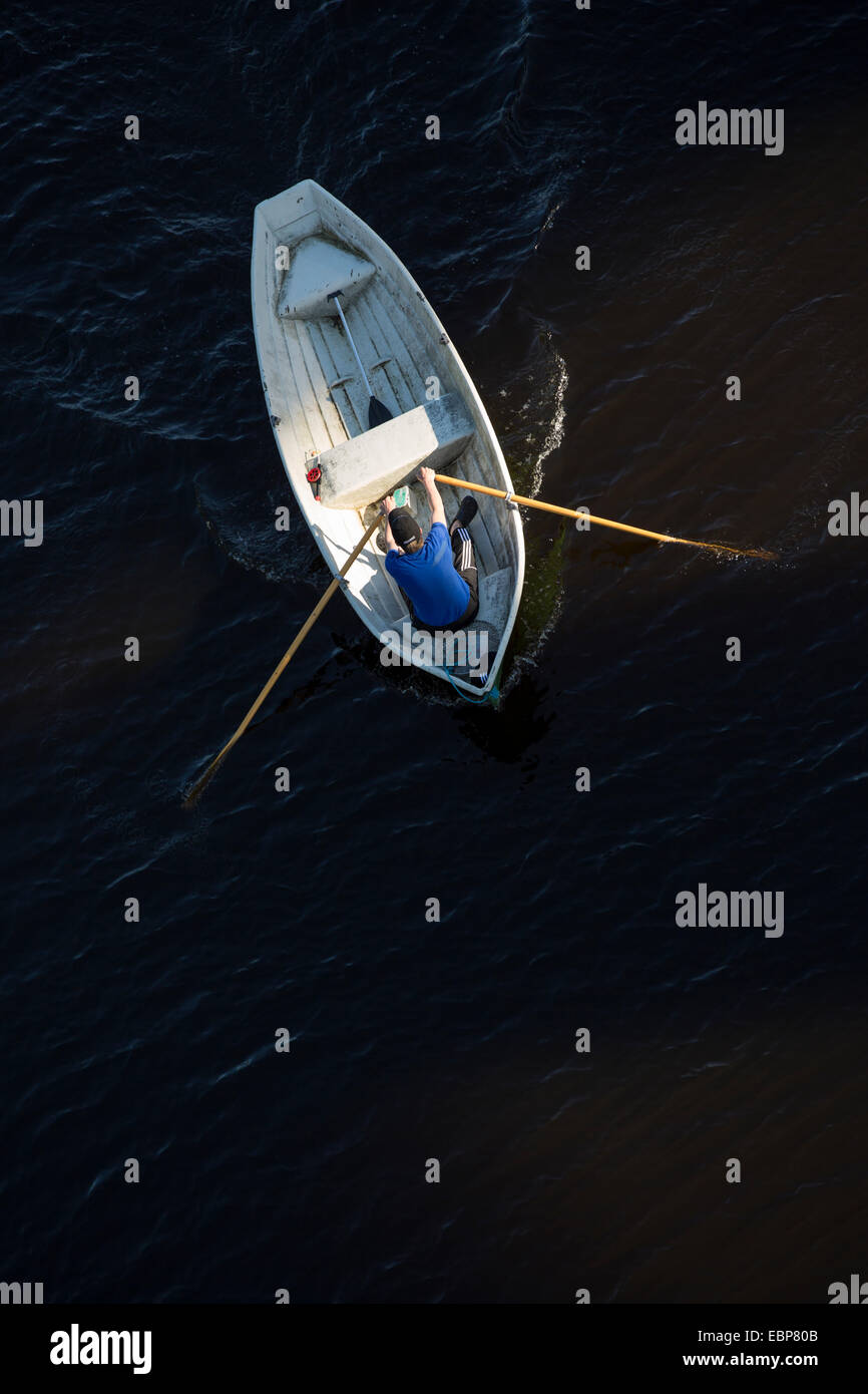 Luftaufnahme eines Mannes, der ein Fiberglas-Ruderboot / Skiff / Schlauchboot rudert, Finnland Stockfoto