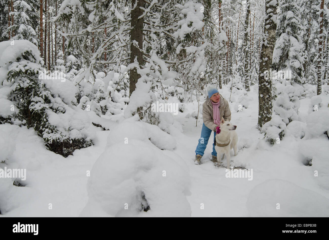 Die Frau mit einem Hund auf Spaziergang im Wald winter Stockfoto