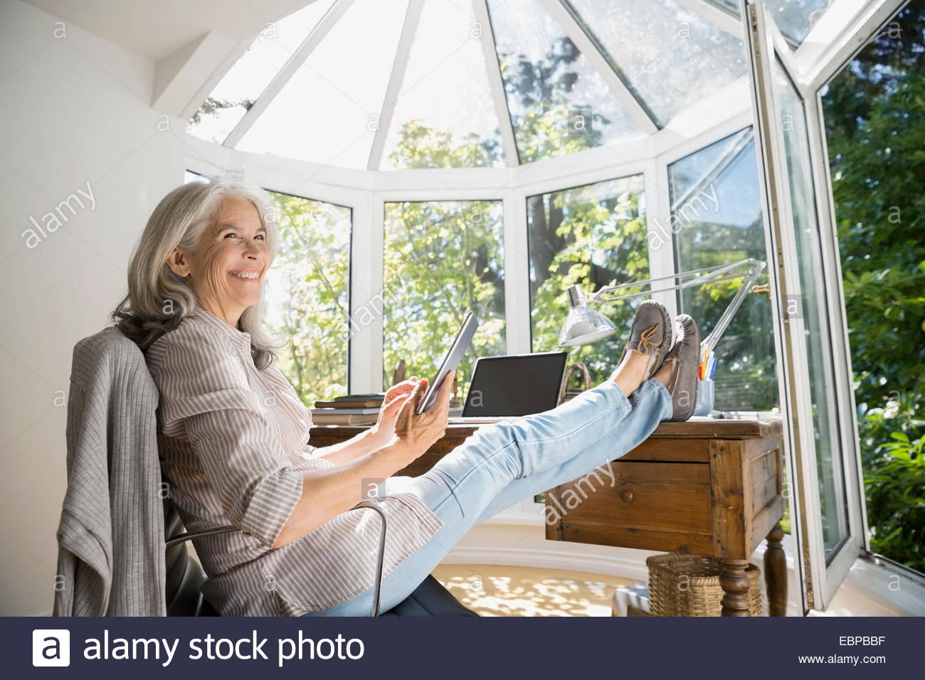 Ältere Frau mit Füßen, im home-office Stockfoto