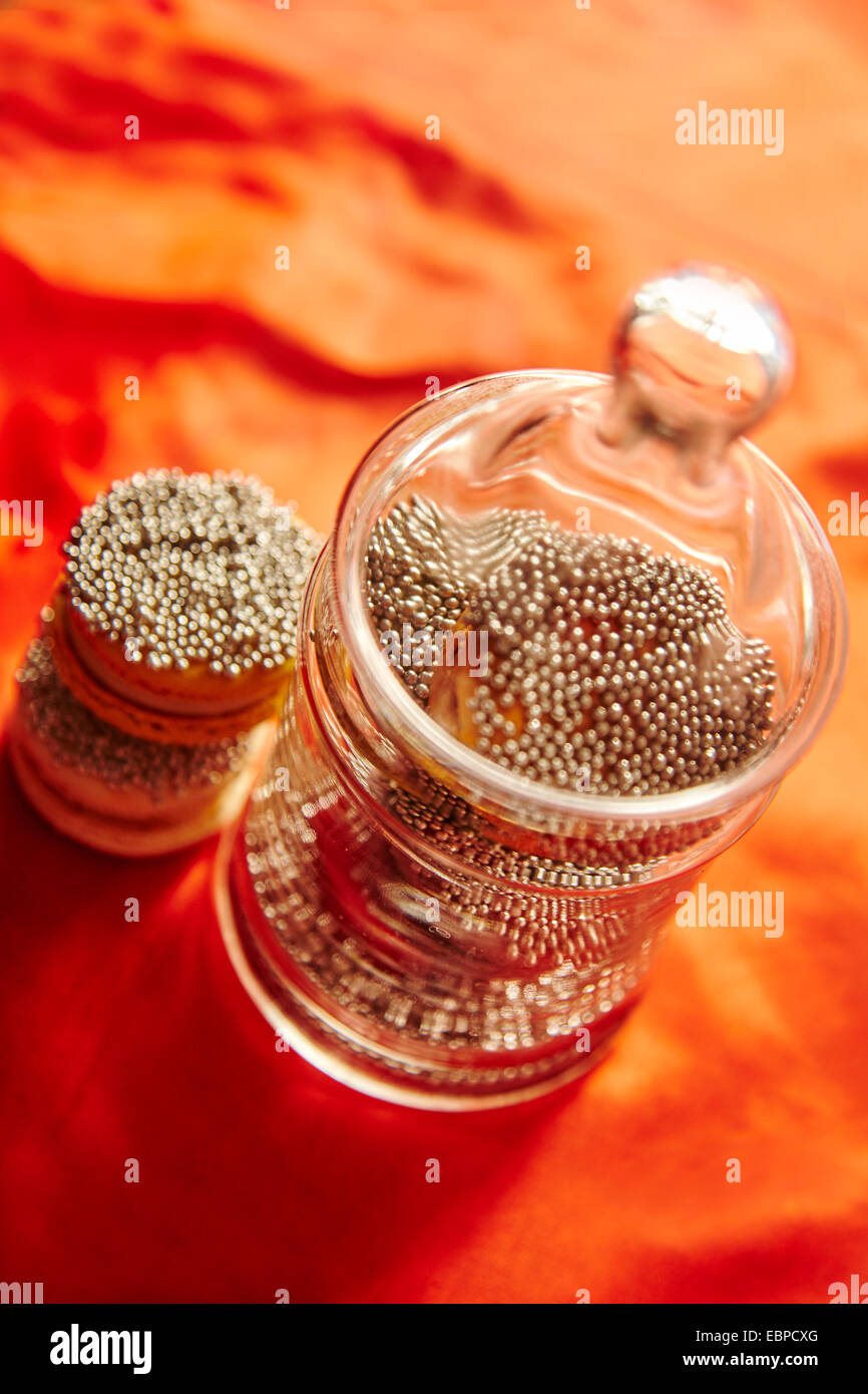 Funkelnde Makronen Cookies in einem Glas für die Feiertage orange Tischdecke Stockfoto