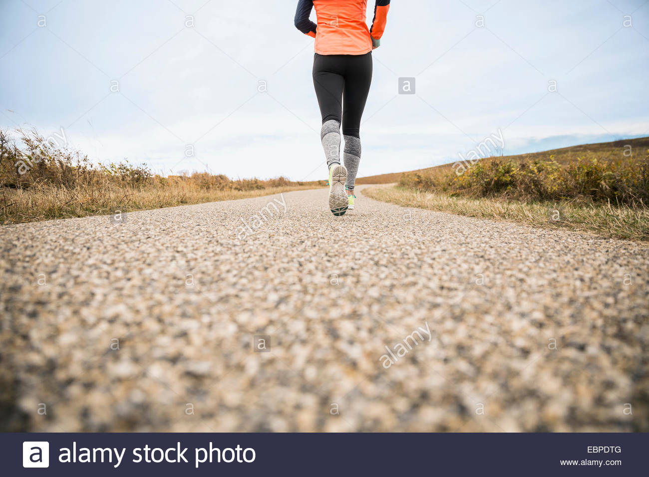 Frau läuft auf ländlichen Weg Stockfoto