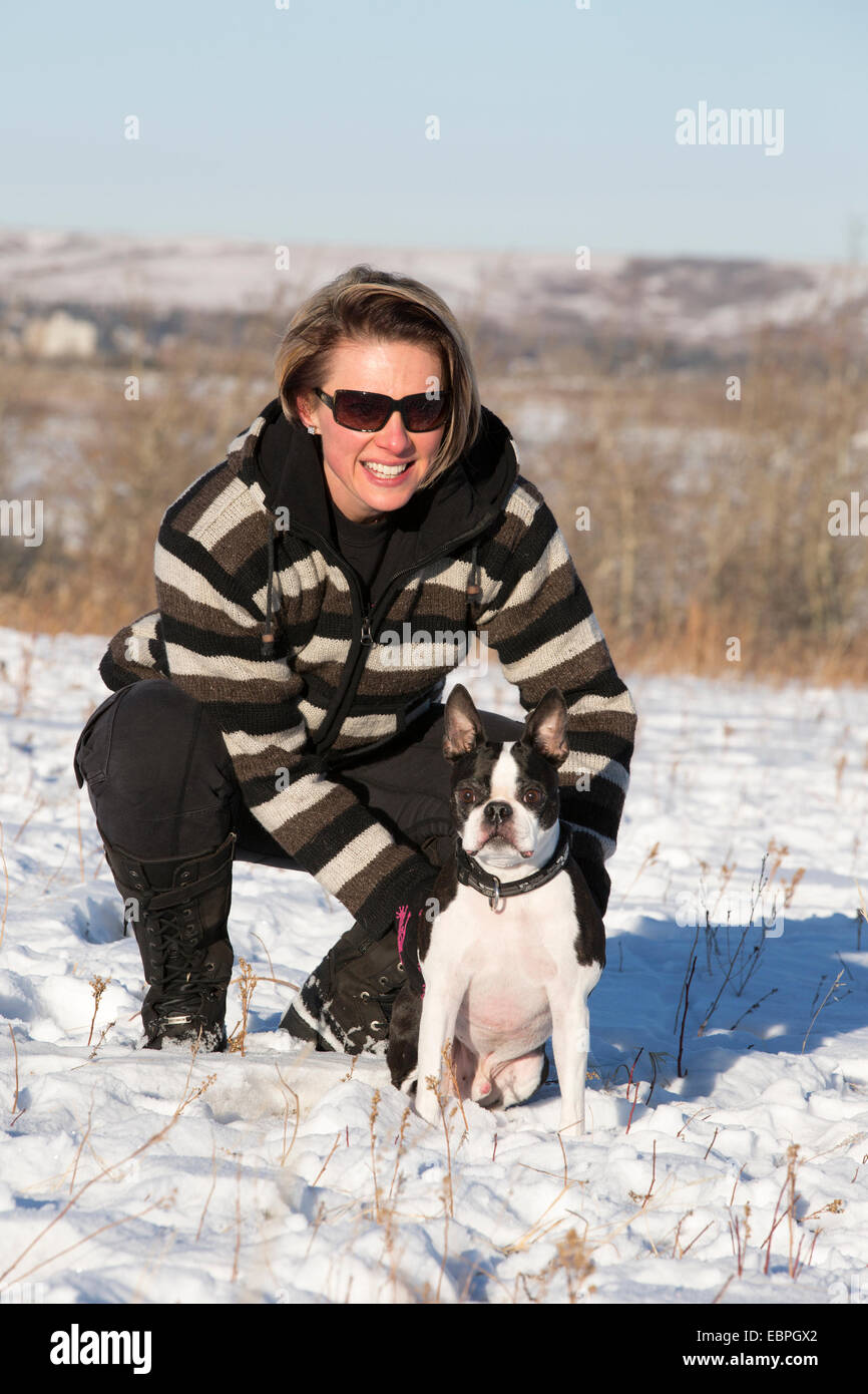 Frau mit dem 11 Jahre alten Boston Terrier, die die Natur im Stadtpark genießt Stockfoto