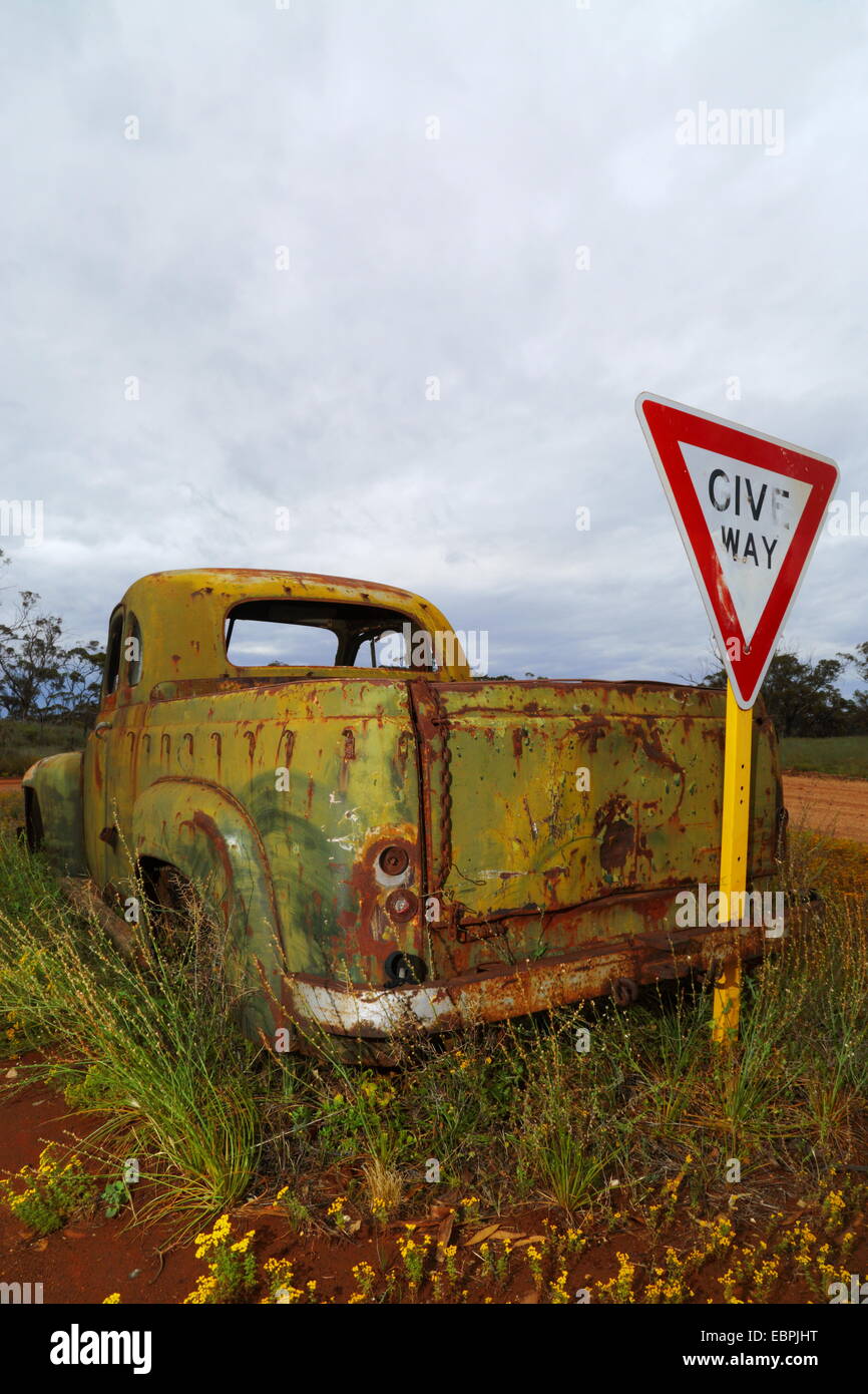 Eine alte rostige Pickup-Truck und geben Wege Schild unter Gewitterhimmel auf einer Farm in Western Australia. Stockfoto
