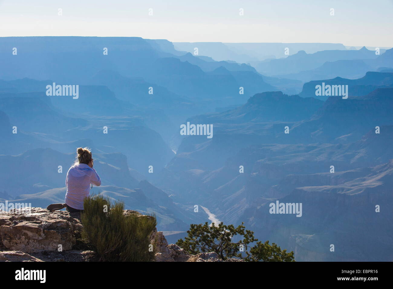 Frau sitzt auf dem Felsen der Wüste Aussichtspunkt über den Grand Canyon, UNESCO-Weltkulturerbe, Arizona, USA Stockfoto