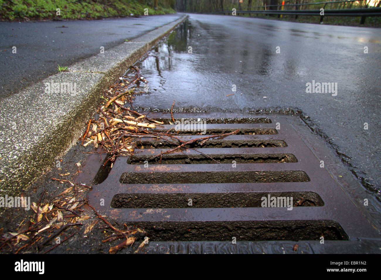 Regenwasser-streaming in einer Rinne Loch, Deutschland Stockfoto