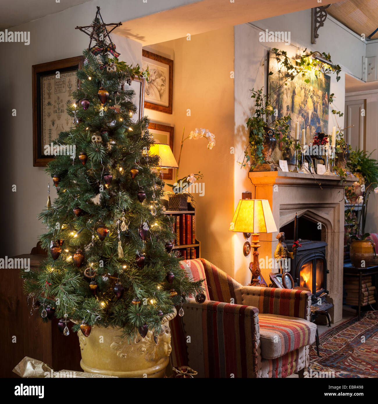 Weihnachtsbaum im Wohnzimmer mit Kelim Stil Polstermöbel, Sessel, Kamin und persische Wolldecke Stockfoto