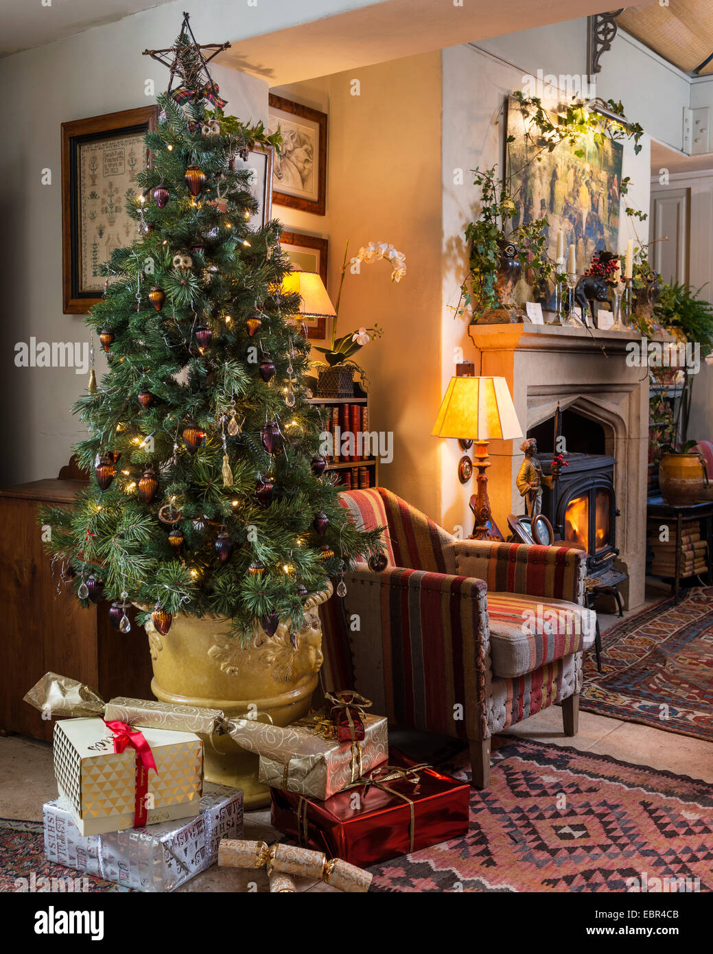 Weihnachtsbaum im Wohnzimmer mit Kelim Stil Polstermöbel, Sessel, Kamin und persische Wolldecke Stockfoto