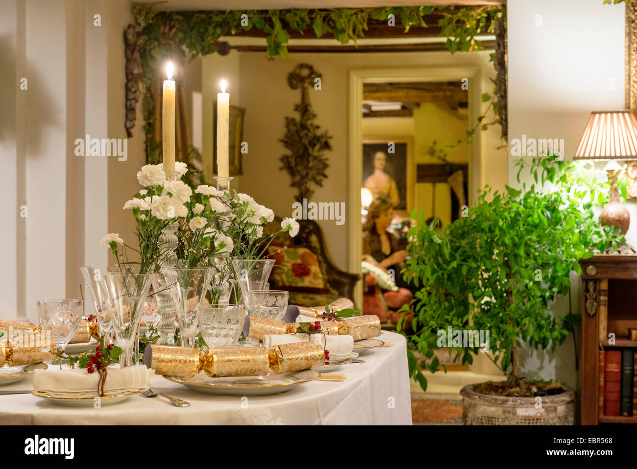 Weißen Nelken und Kerzen schmücken einen Tisch elegant gelegt für das Weihnachtsessen Stockfoto