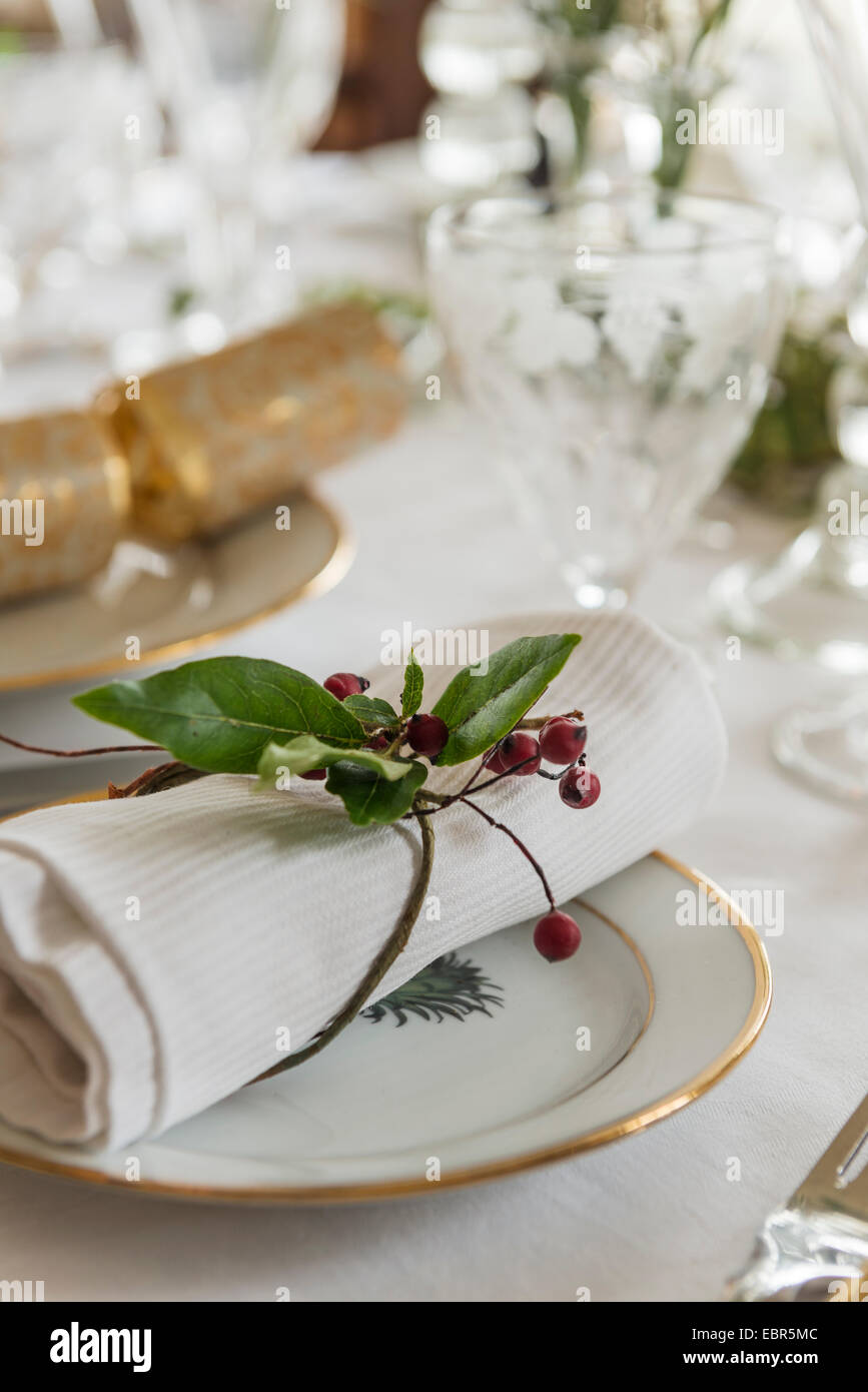 Zweig der Stechpalme verwendet für Serviettenring am Tisch Platz für das Weihnachtsessen Stockfoto