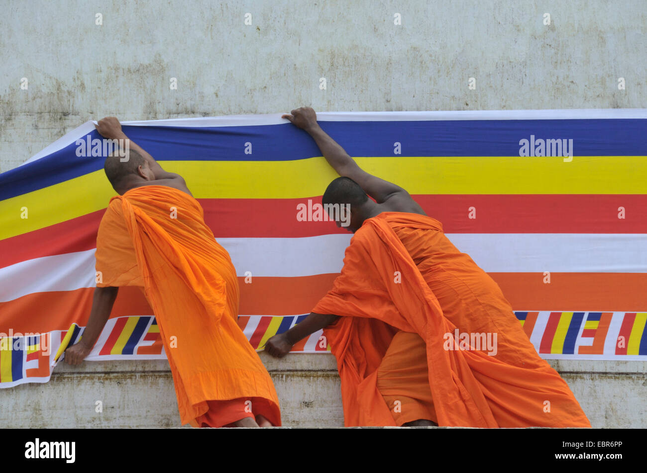 Mönche setzen eine lange buddhistische Flagge um die Ruvanveli Seya Dagoba, Puja, Sri Lanka, Anuradhapura Stockfoto