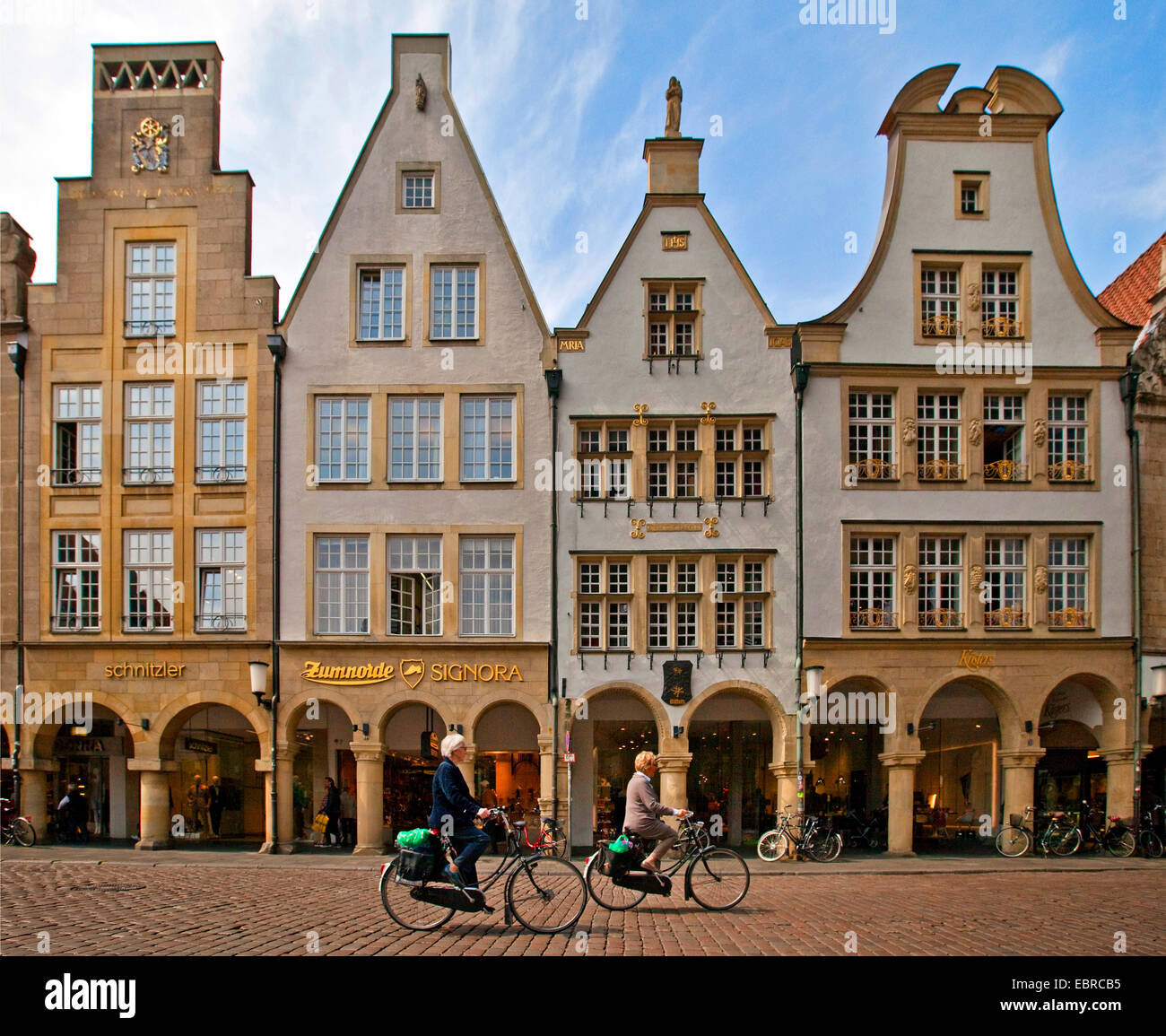 zwei weibliche Radfahrer vor einer Häuserzeile mit Bögen am Prinzipalmarkt, Deutschland, Nordrhein-Westfalen, Münsterland, Münster Stockfoto