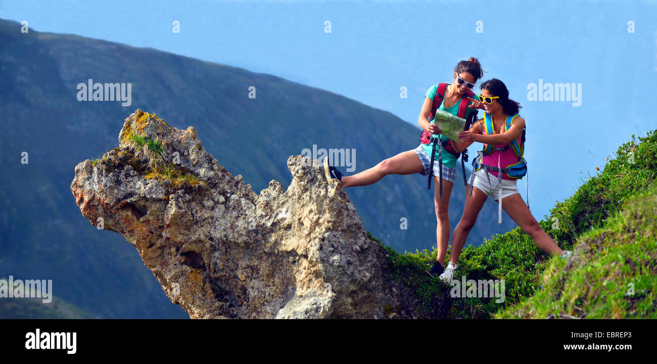 zwei junge weibliche Wanderer auf einem Felsvorsprung, der Blick auf eine Karte, Frankreich, Savoyen, Nationalpark Vanoise Stockfoto