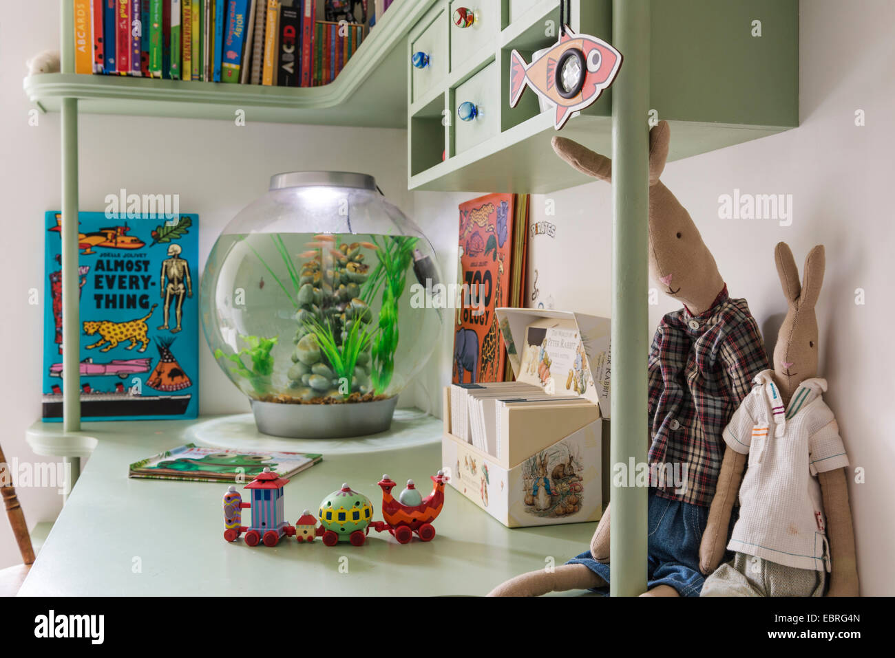 Kinder Schreibtisch mit Büchern, Spielzeug und Goldfischglas Stockfoto