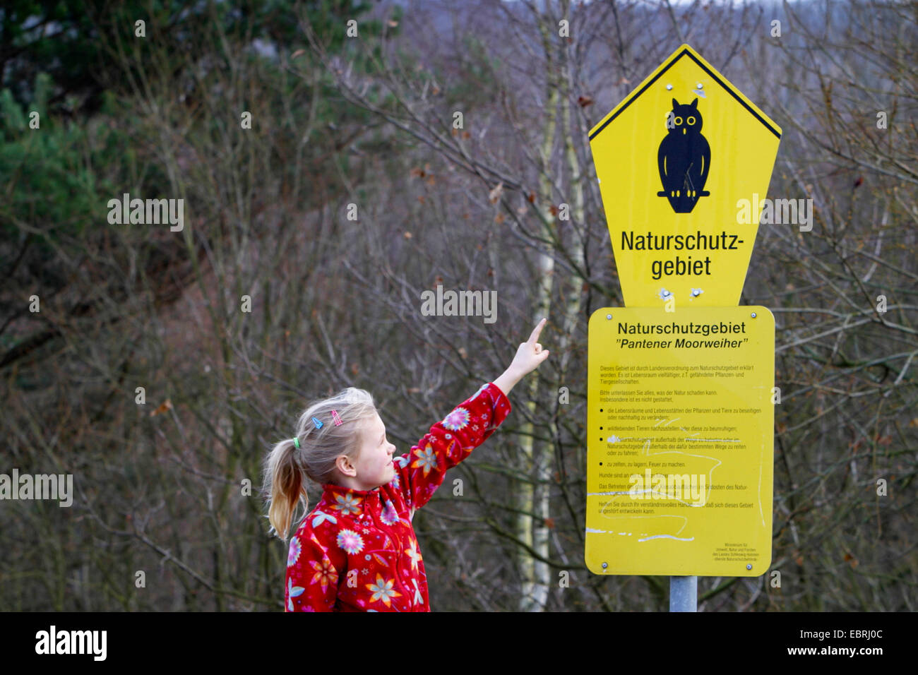 Mädchen zeigt auf einem Naturschutzgebiet unterzeichnen Pantener Moorweiher, Deutschland Stockfoto