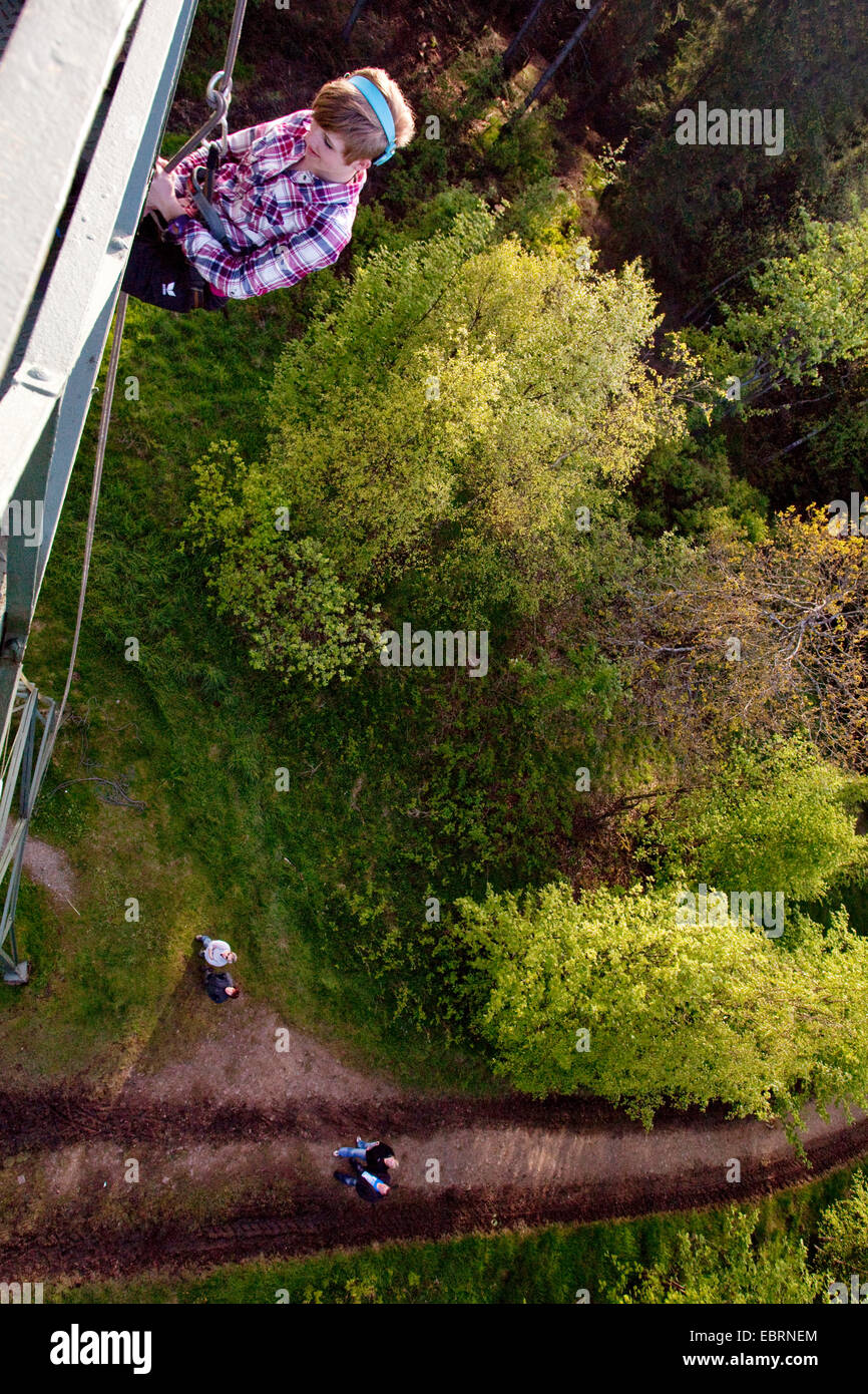 junge Frau Havin Spaß Abseilen aus der Gillerturm während beobachtet von Zuschauern auf dem Boden, Hilchenbach, Siegerland, NRW, Deutschland Stockfoto