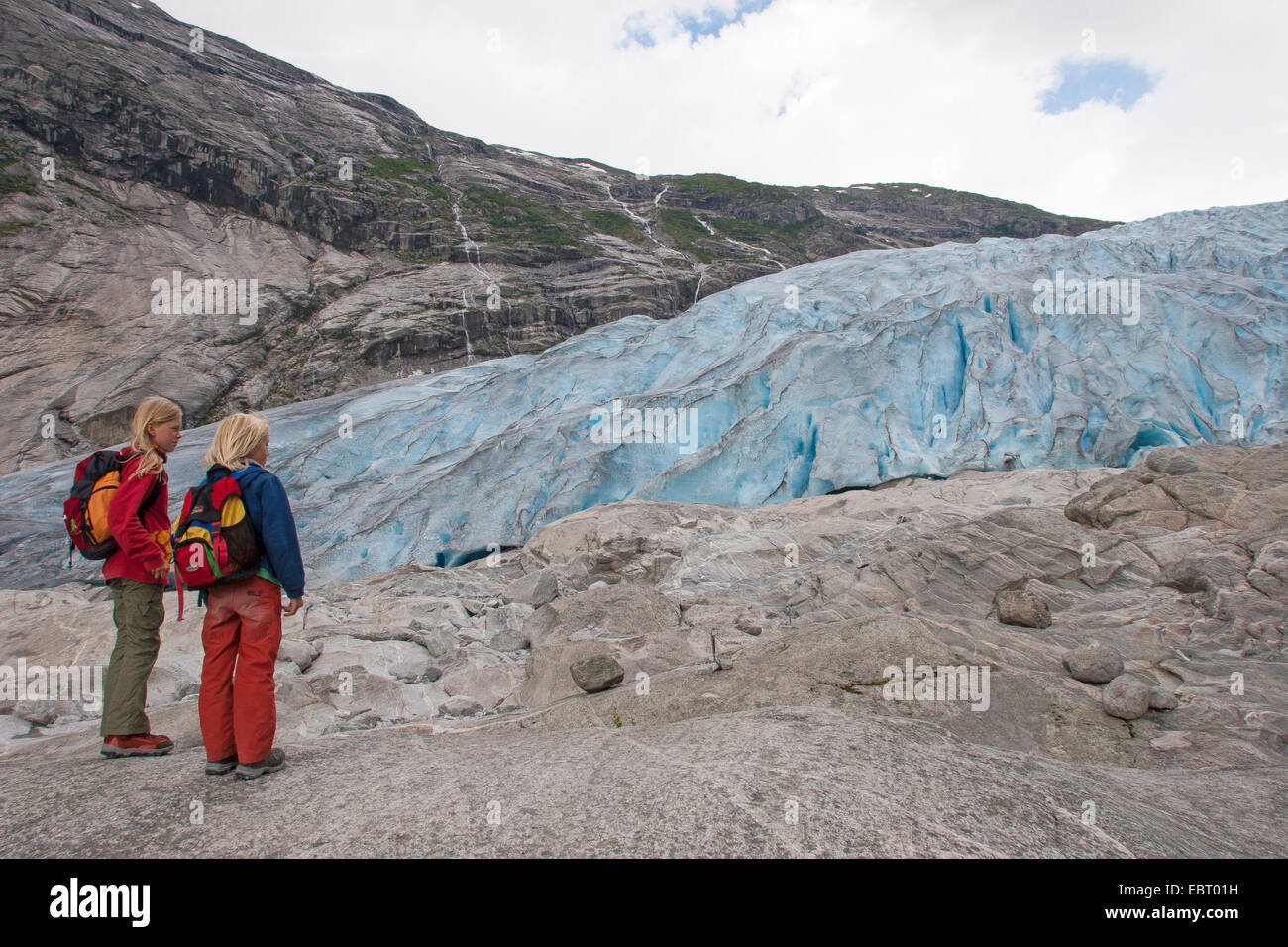 zwei Kinder stehen vor Nigardsbreen Gletscher Zunge, Norwegen, Nationalpark Jostedalsbreen Stockfoto