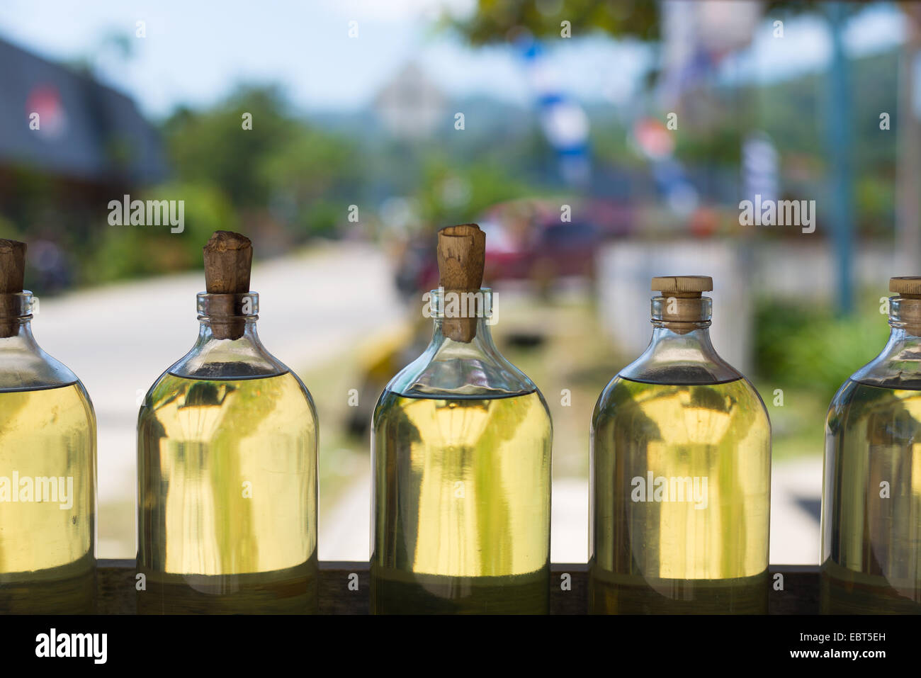 Selektiven Fokus auf einer Reihe von Glasflaschen gefüllt mit transparenten goldene Flüssigkeit wie Motoröl, Speiseöl, Benzin, Benzin. Stockfoto