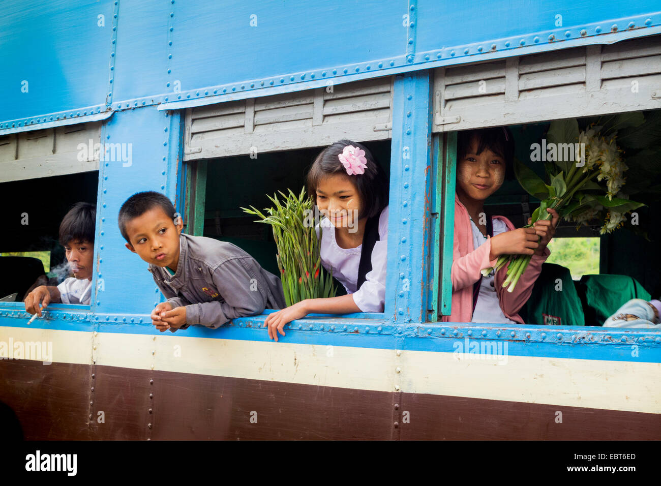 Kinder schauen aus dem Fenster des Zuges und Blumen zu kaufen, von der örtlichen Bevölkerung an einer Station in der Nähe von Kalaw, Burma, Myanmar Stockfoto