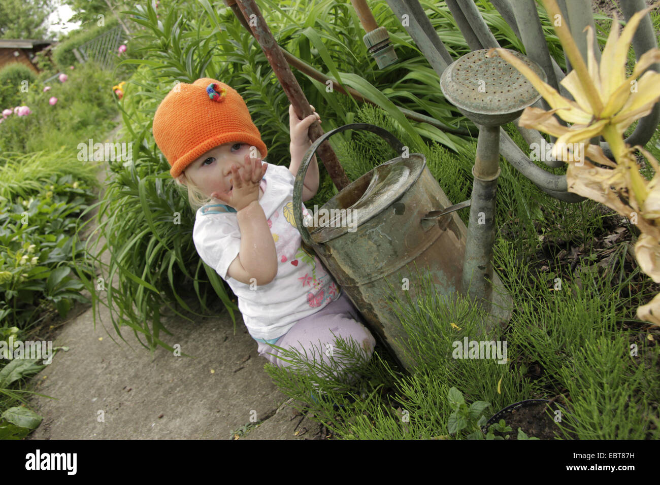kleine Mädchen spielen mit einer Gießkanne, Deutschland Stockfoto
