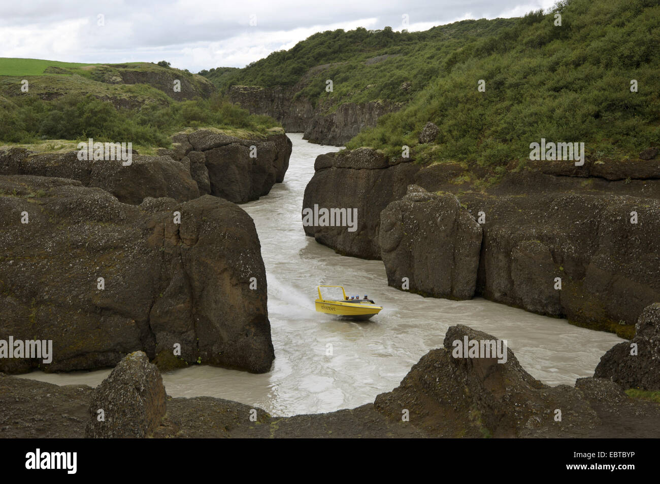 Motorboot am Fluss Hvita läuft durch eine malerische Schlucht, Island Stockfoto
