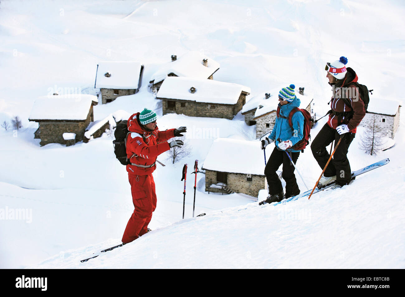 drei junge Skifahrer an einem verschneiten Hang über den Dächern des Wintersports zurückgreifen, Frankreich, Savoyen, Sainte-Foy Stockfoto