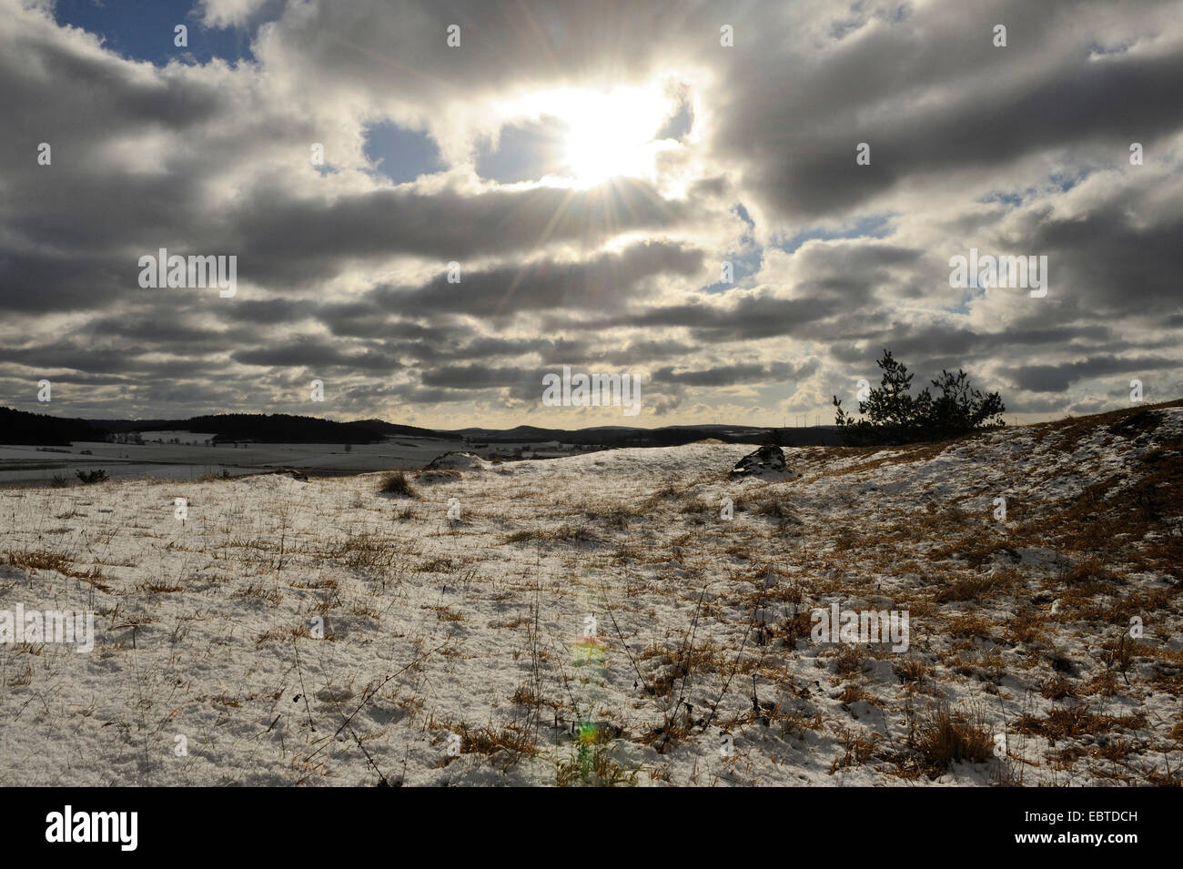 Sonnenstrahlen brechen durch Wolken über Wiese im Winter, Deutschland, Bayern, Oberpfalz Stockfoto