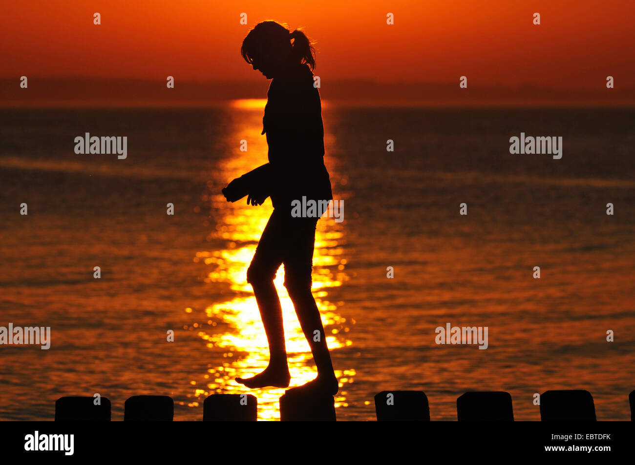 Frau zu Fuß auf Buhne bei Sonnenuntergang, Deutschland, Mecklenburg-Vorpommern Stockfoto