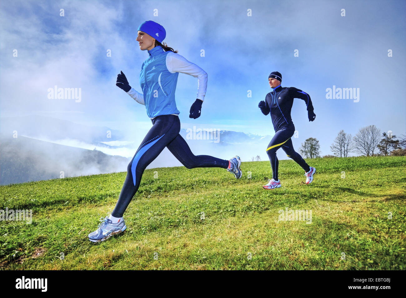 junge sportliche paar quer Bergwiese Stockfoto