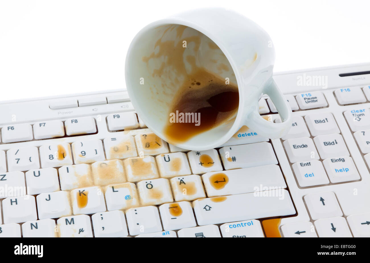 Tasse Kaffee verschüttet auf einer Computertastatur Stockfoto