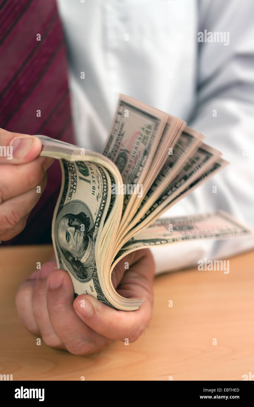 Business-Mann ein Bündel Dollarnoten durchblättern Stockfoto