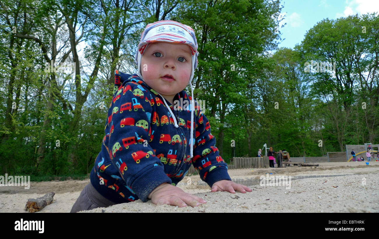 kleiner Junge spielt im Sandkasten auf Spielplatz Stockfoto