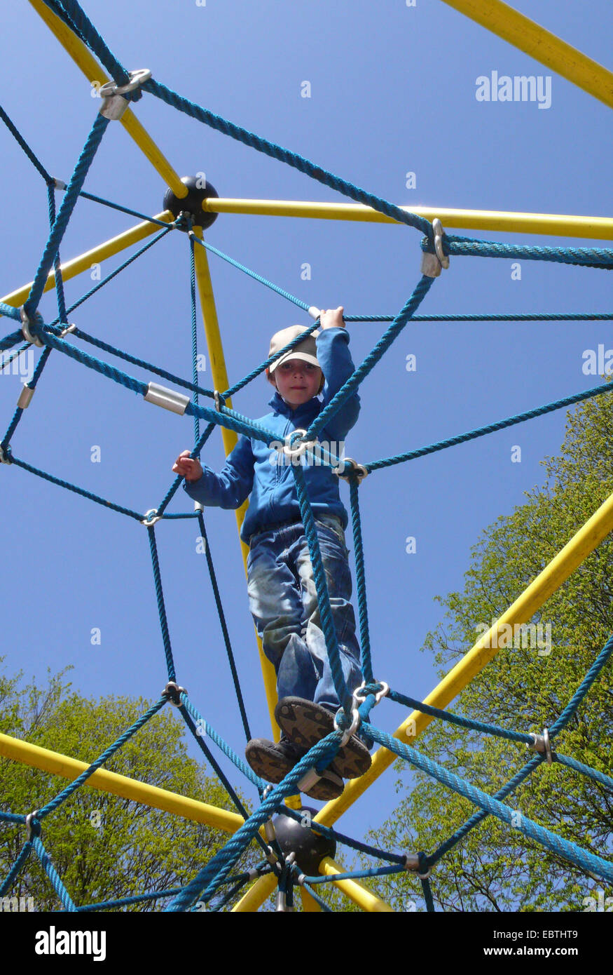 kleiner Junge auf einen kletternden Apparat auf einem Spielplatz Stockfoto