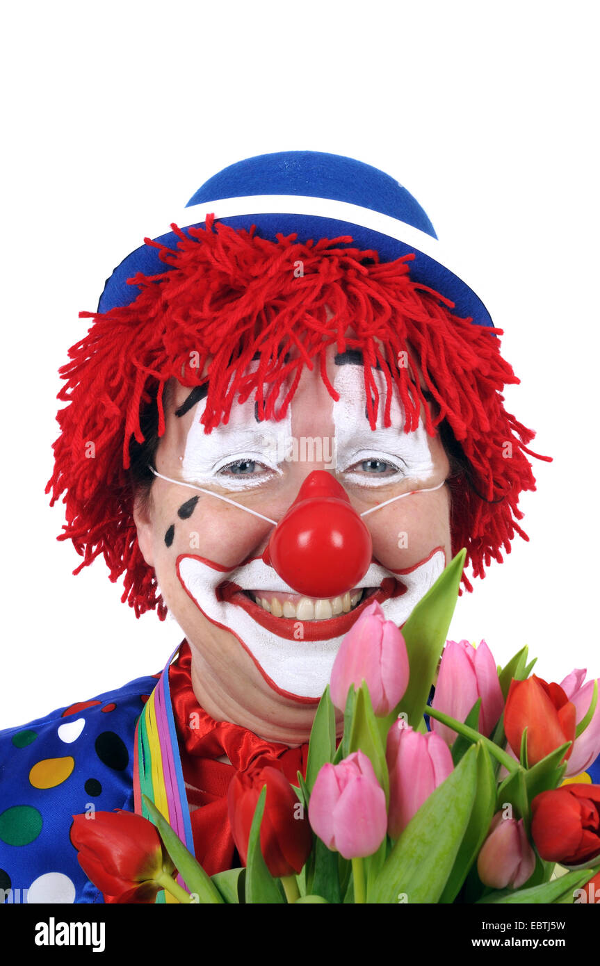 Frau verkleidet wie ein Clown weht Konfetti Stockfoto