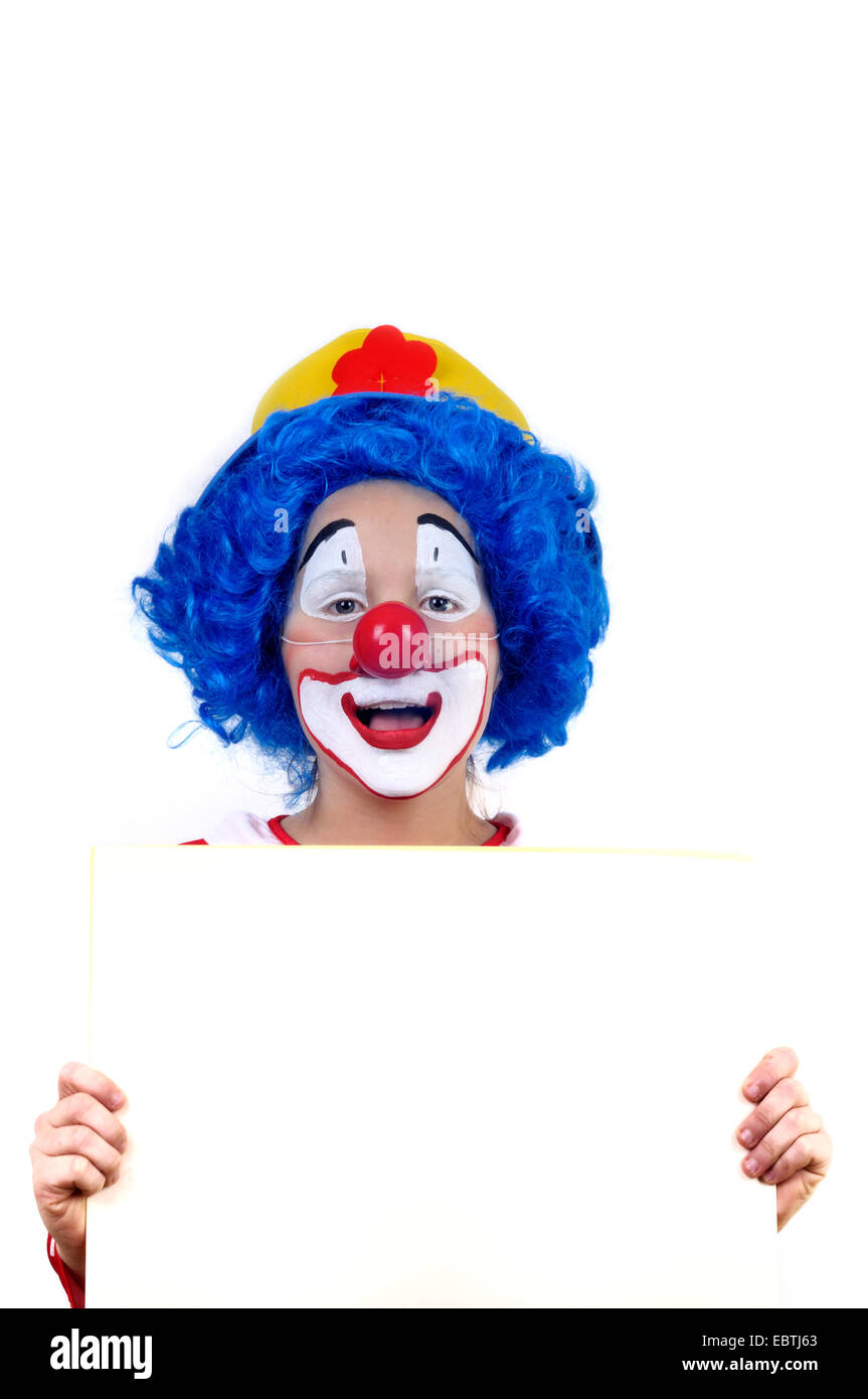 kleine Clown mit gelben Hut, blauer Perücke und falsche rote Nase weiß Papier halten Stockfoto