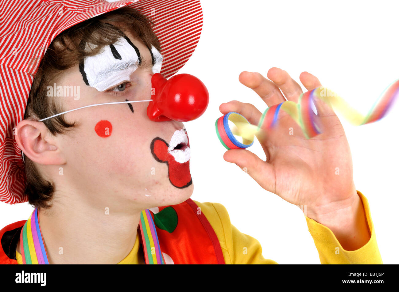Clown in einem Papier-Streamer weht Stockfoto
