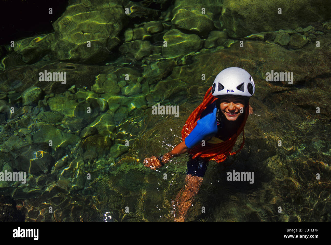 junge Frau mit Kletterausrüstung im Wasser des Le Fiumicelli, Bavella Gebirge, Frankreich, Korsika, Porto Vecchio Stockfoto