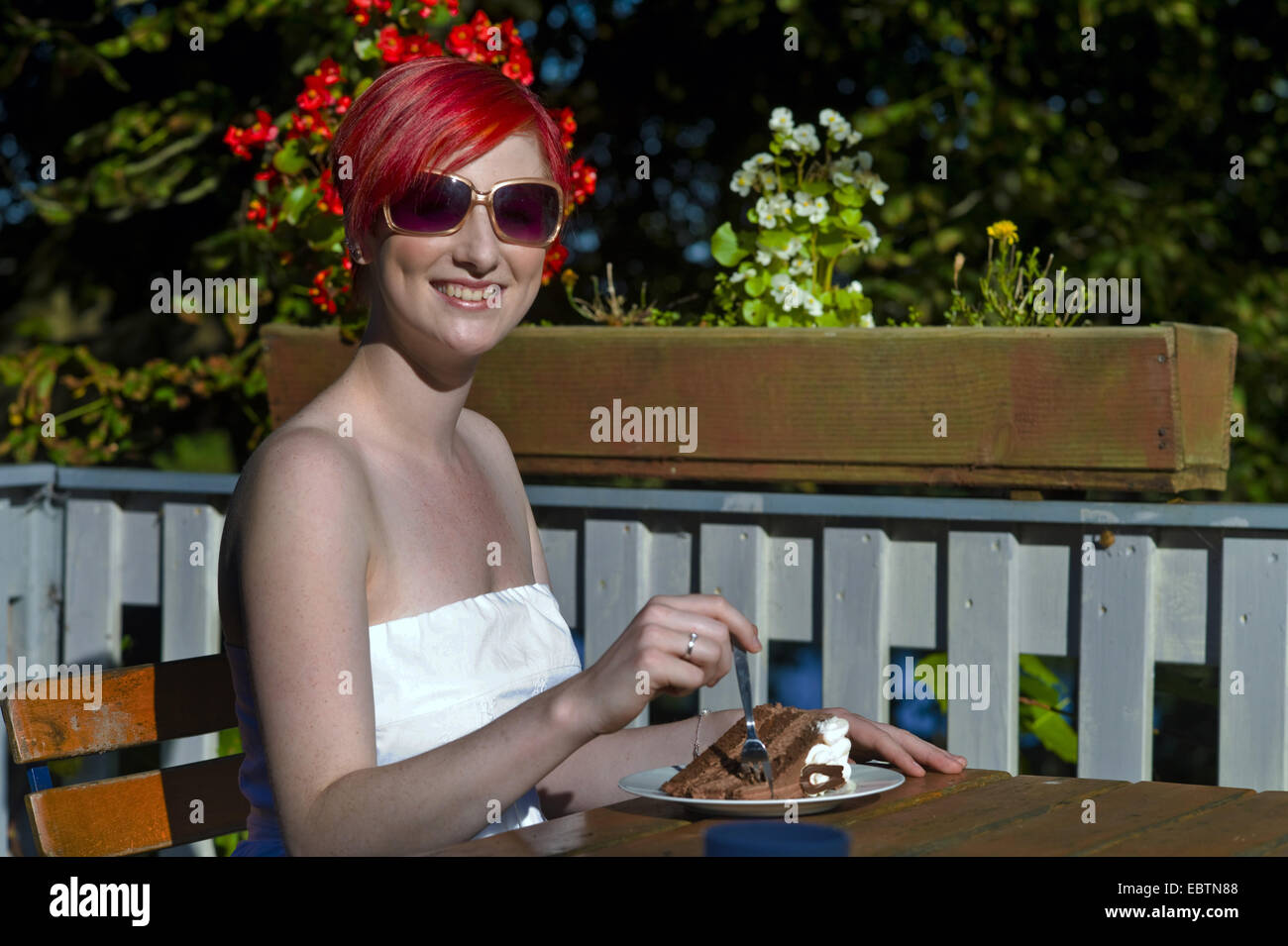 junge rothaarige Frau Essen einen Stück Kuchen, Deutschland Stockfoto