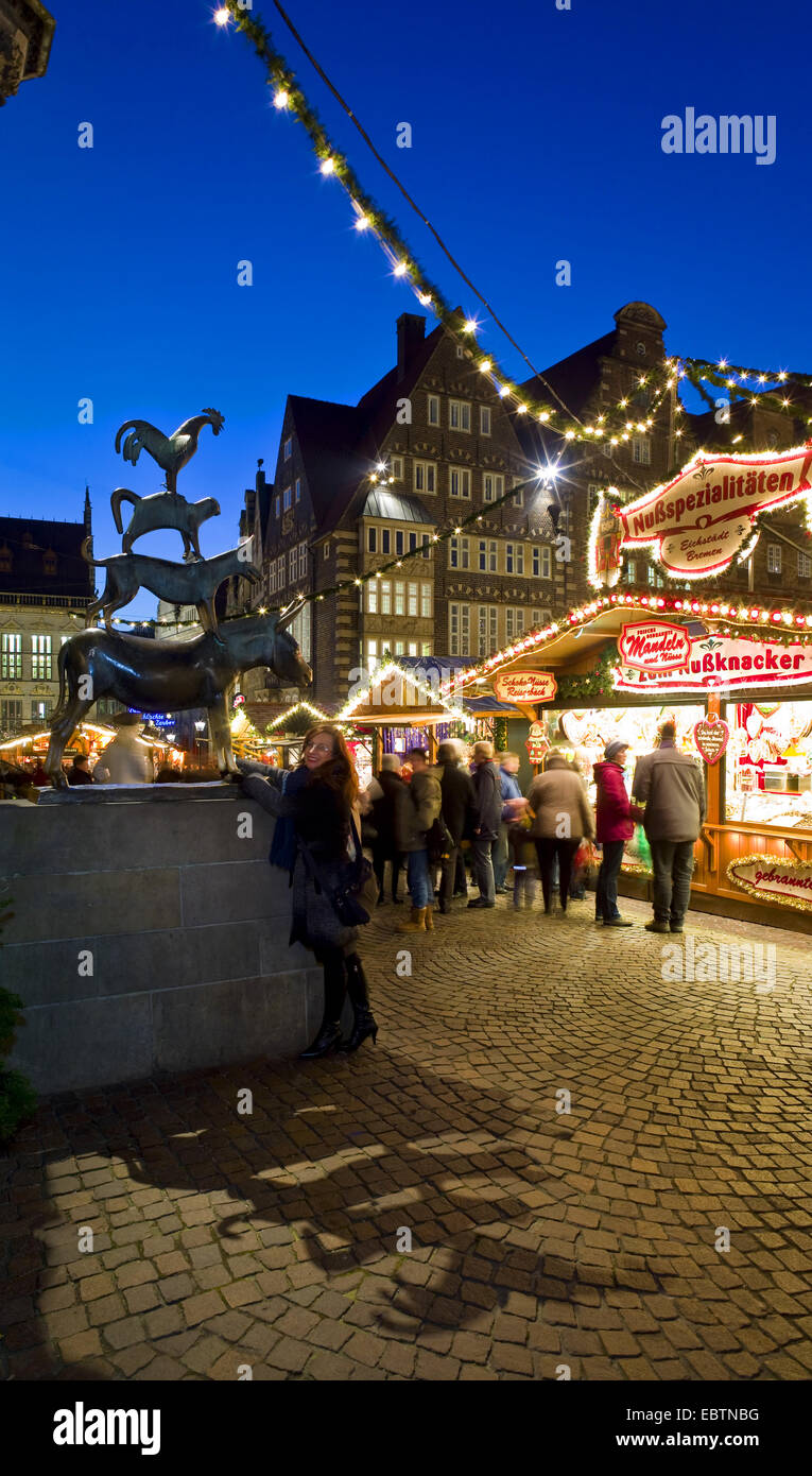 Frau auf dem Weihnachtsmarkt berühren die Esel vorderen Hufen des Bremer Musiker wünschen kommen wahr, Deutschland, Bremen Stockfoto